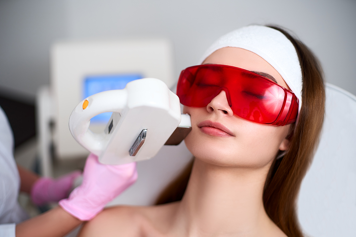 Woman undergoing microneedling radiofrequency treatment on her face in a medical aesthetic clinic.