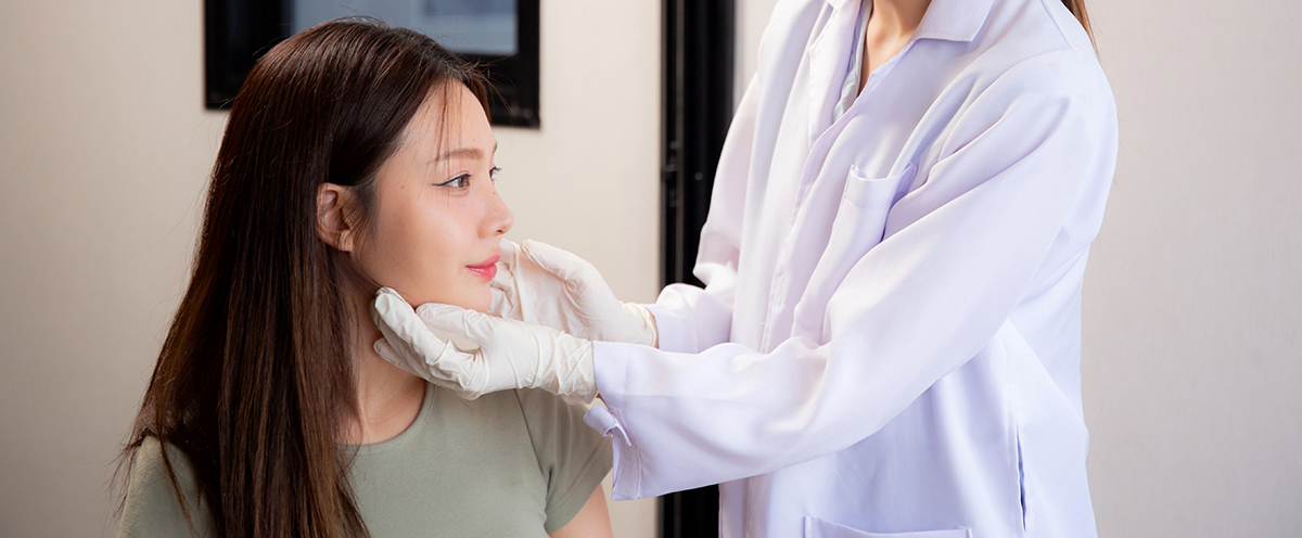 Patient seated in a clinic during a consultation for aesthetic treatment options.